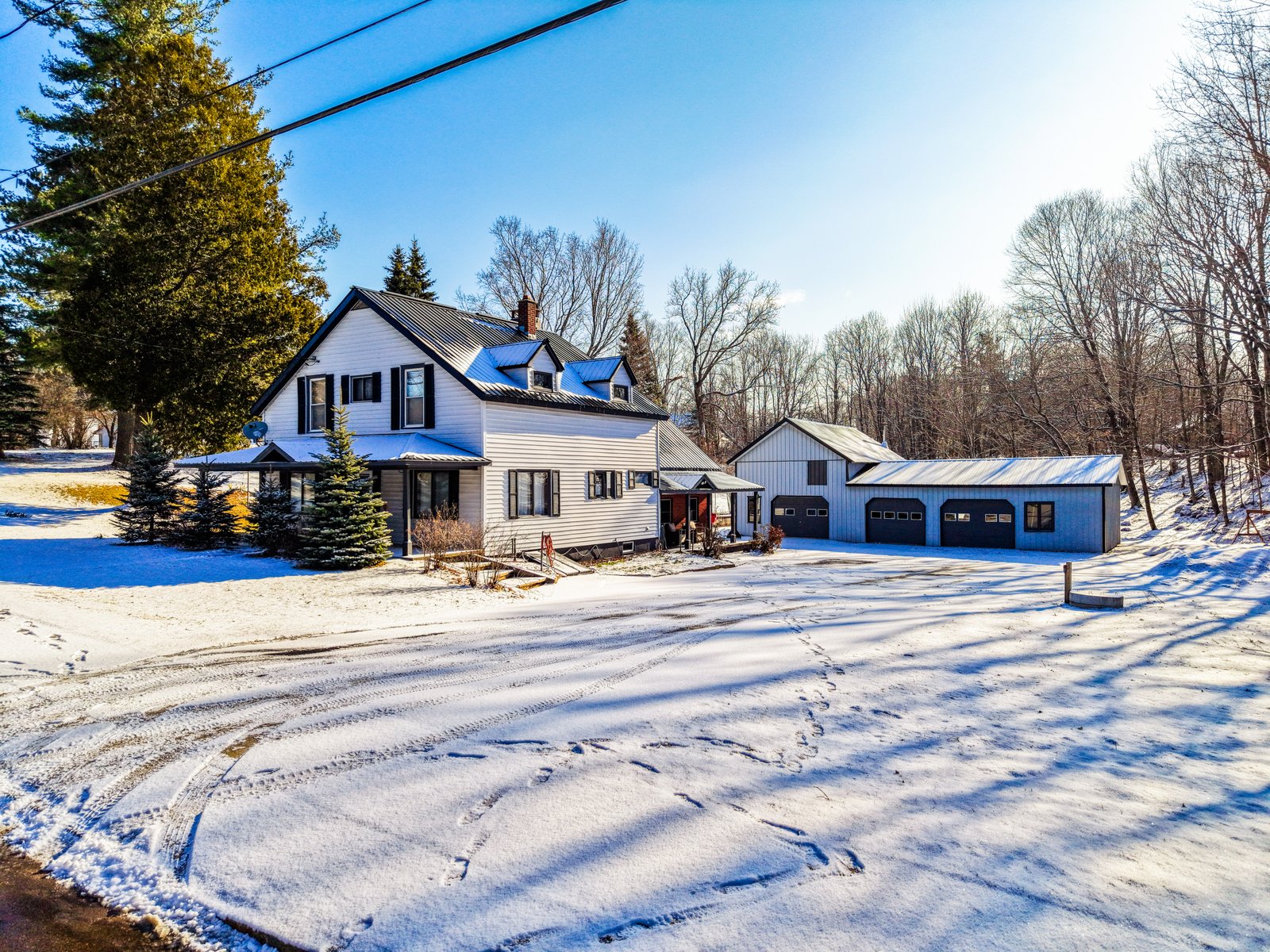 Aerial drone frame of a North Country property with outbuildings and acreage