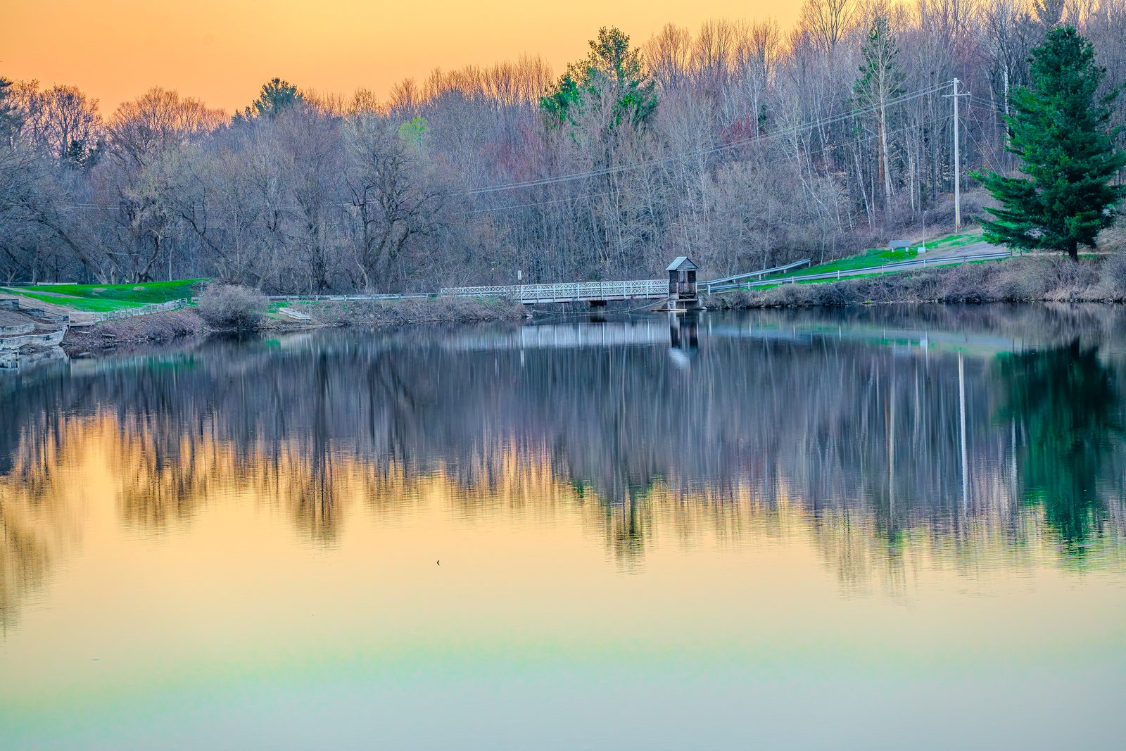 Adirondack pond at sunset, footbridge — twilight HDR by Apex Pack Media
