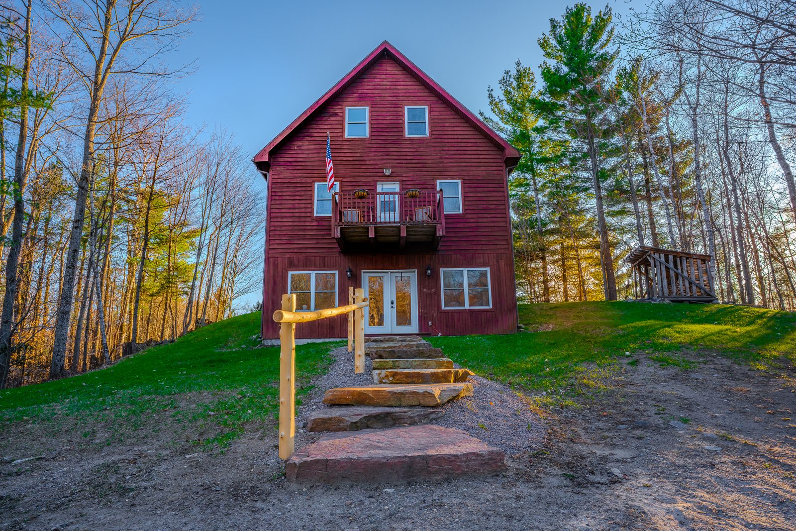 Red farmhouse twilight with American flag