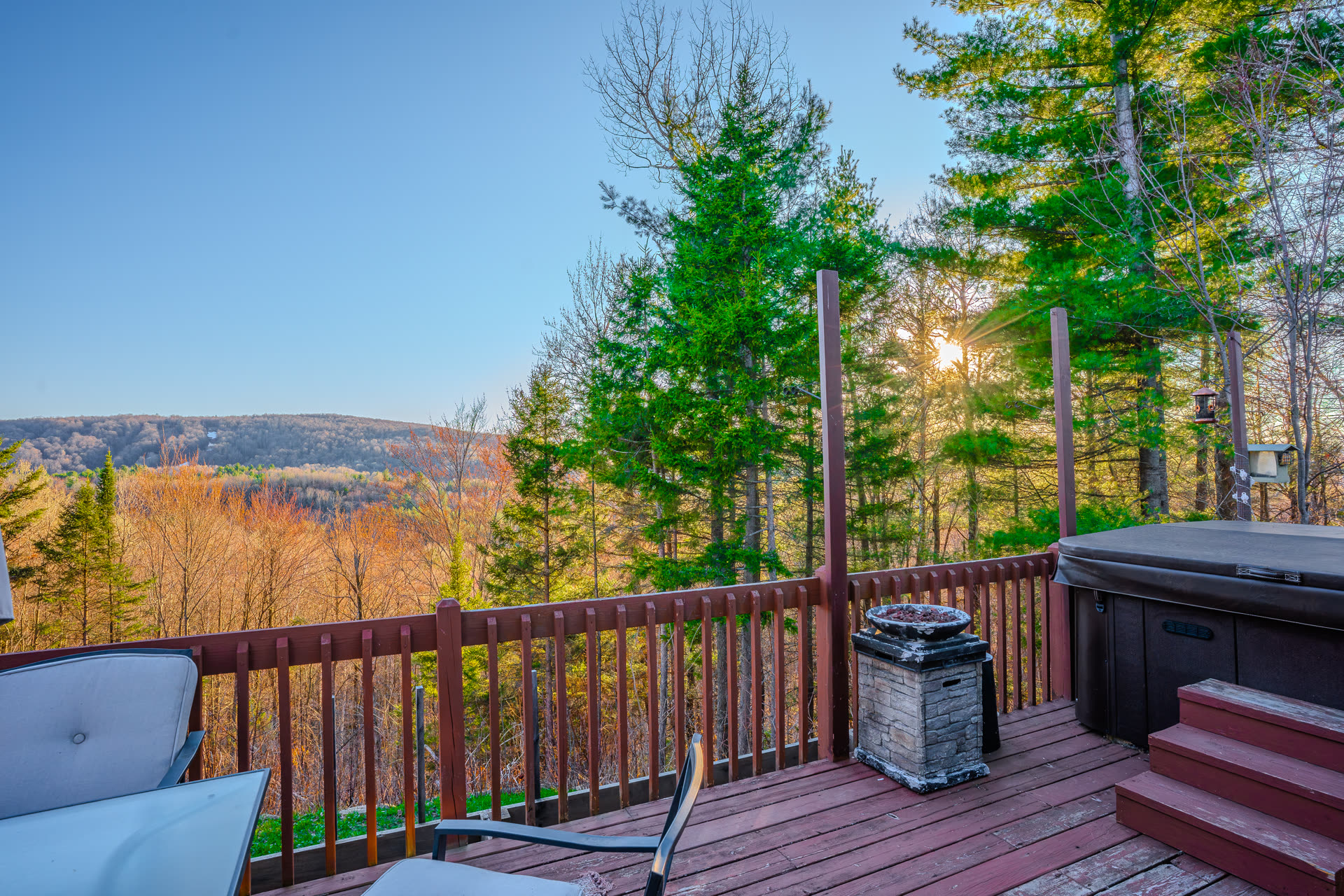 Back deck with hot tub overlooking a hilltop view at golden hour